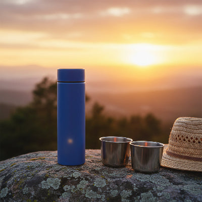 gourde isotherme 500ml bleu sur un rocher devant coucher de soleil